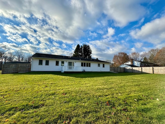 rear view of house with a wooden deck and a yard