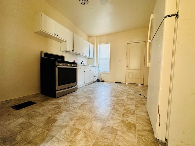 kitchen featuring white cabinetry, white refrigerator, and stainless steel range with gas stovetop