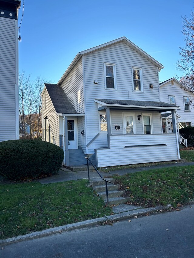 view of front facade with covered porch and a front lawn