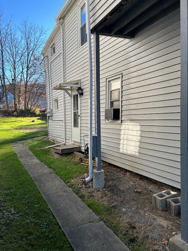 view of side of property featuring cooling unit and a lawn