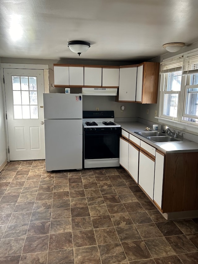 kitchen featuring sink, white appliances, white cabinetry, and a healthy amount of sunlight