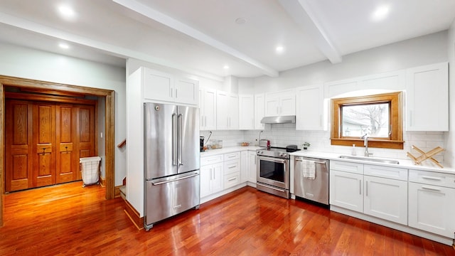 kitchen featuring beam ceiling, dark hardwood / wood-style flooring, white cabinets, and stainless steel appliances