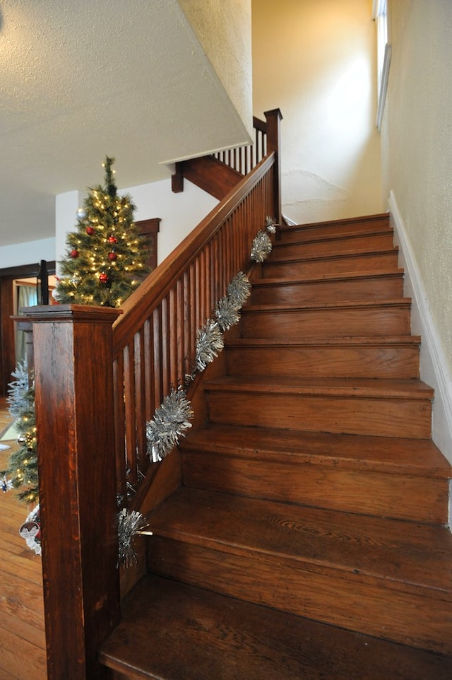 stairs featuring a textured ceiling