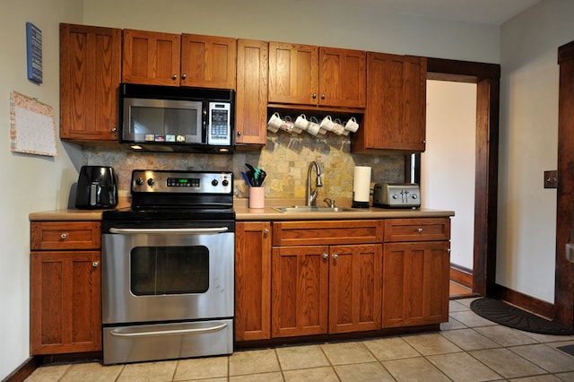 kitchen with light tile patterned flooring, tasteful backsplash, stainless steel electric range oven, and sink