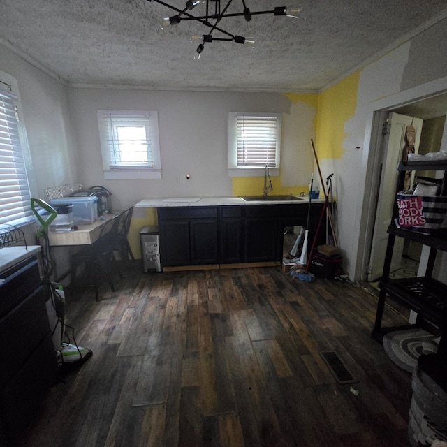 interior space with a textured ceiling, crown molding, sink, and dark wood-type flooring