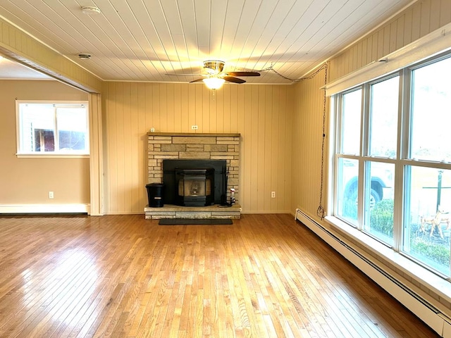 unfurnished living room with wood ceiling, light hardwood / wood-style floors, and baseboard heating