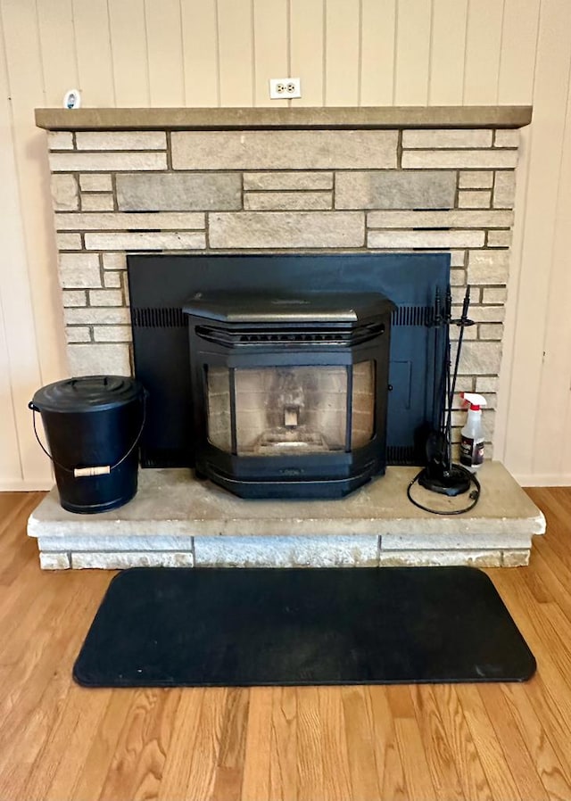 details featuring a wood stove and hardwood / wood-style floors