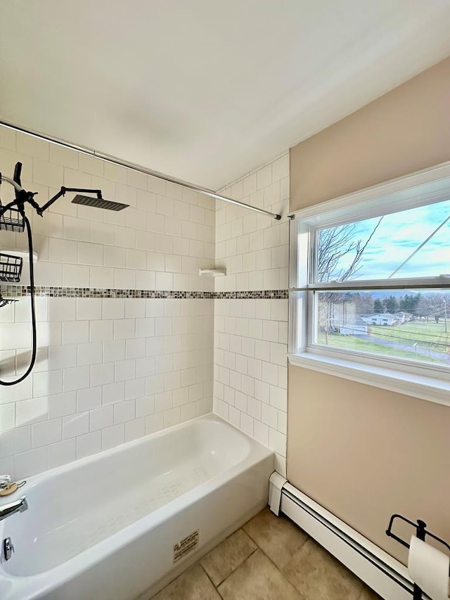 bathroom featuring tile patterned flooring, tiled shower / bath, and a baseboard heating unit