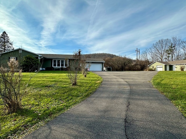 single story home featuring a garage and a front lawn