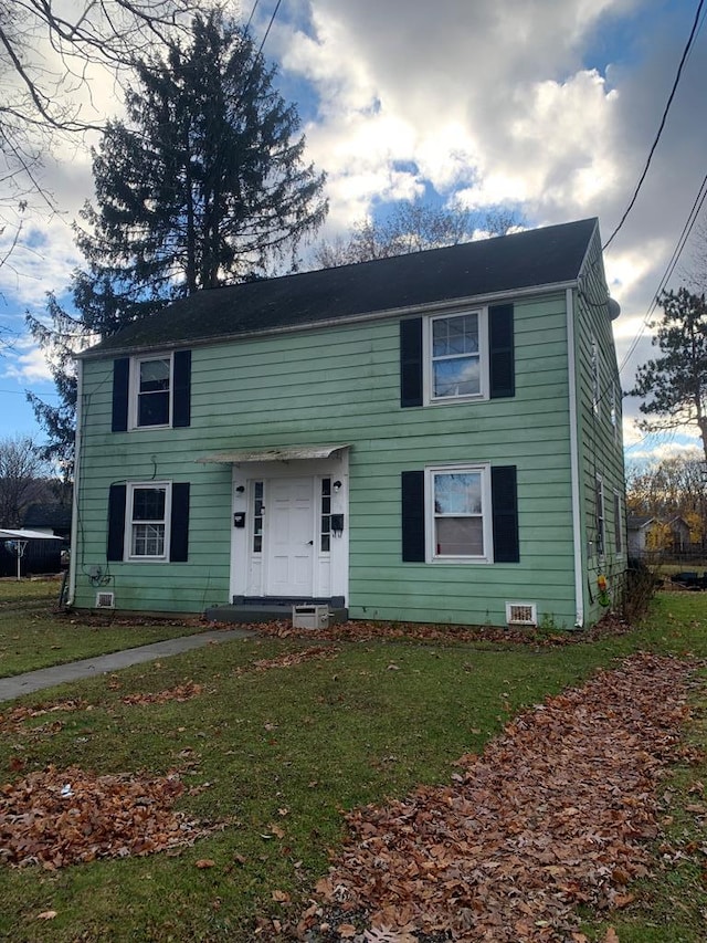 colonial home featuring a front yard