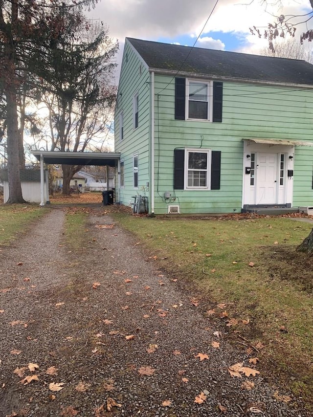 view of front of house with a carport and a front yard