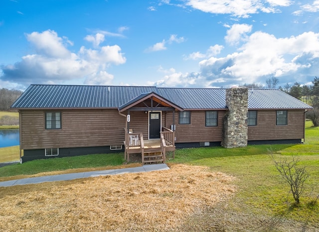 view of front of house featuring a front lawn and a water view