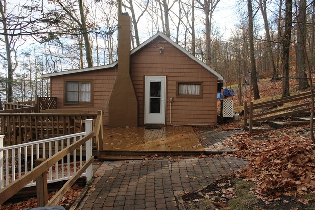 back of property with a wooden deck and a patio area