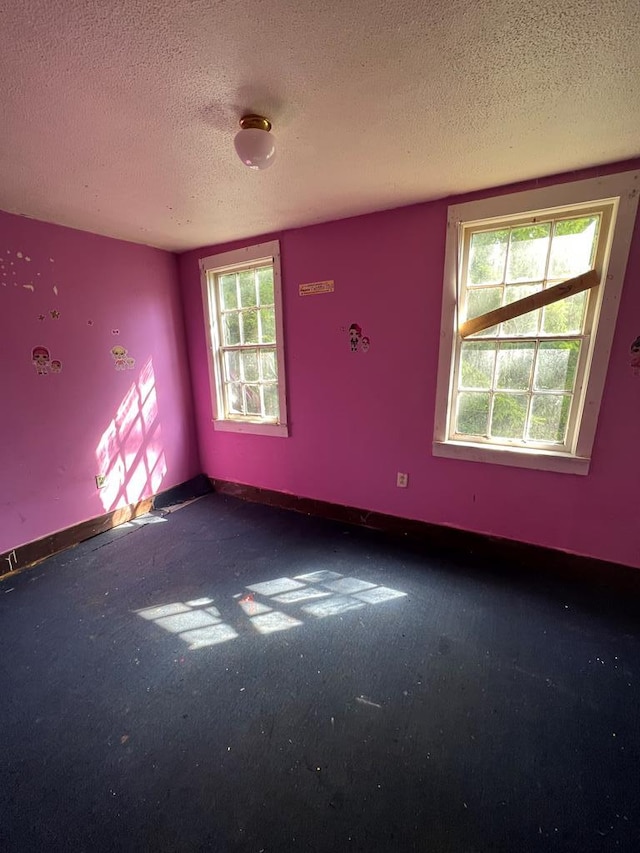 carpeted empty room featuring a textured ceiling