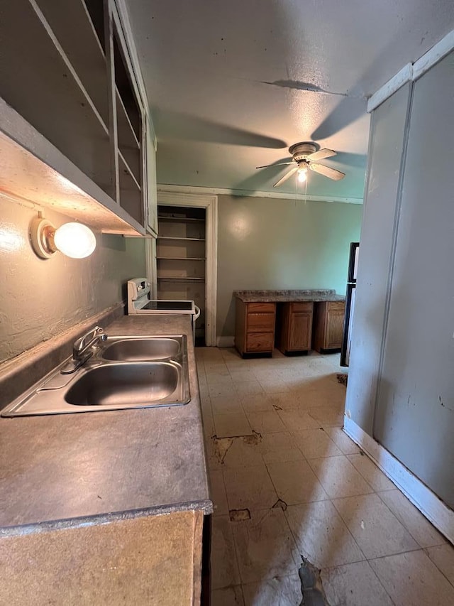 kitchen featuring stove, sink, and ceiling fan