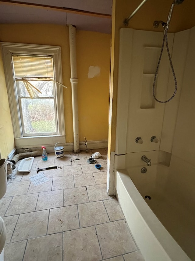 bathroom featuring tile patterned flooring, toilet, and  shower combination