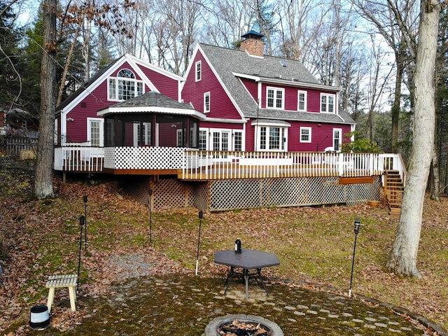 rear view of property featuring a wooden deck, a fire pit, and a gazebo