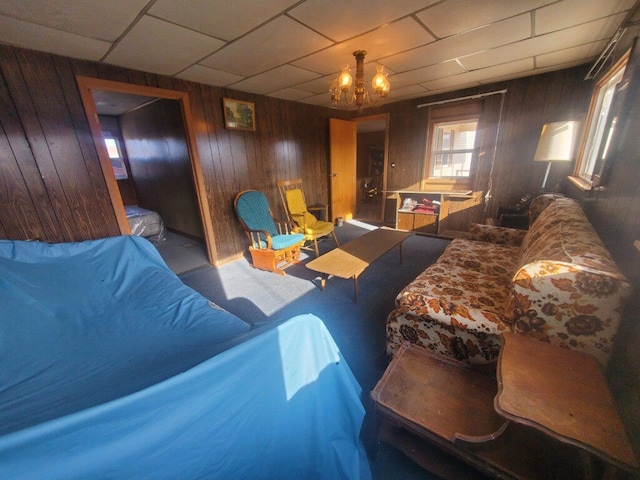 living room featuring wooden walls and a notable chandelier