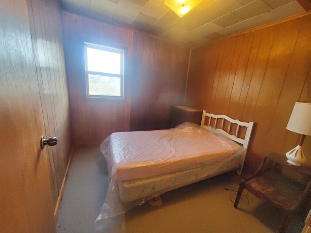 bedroom featuring wooden walls