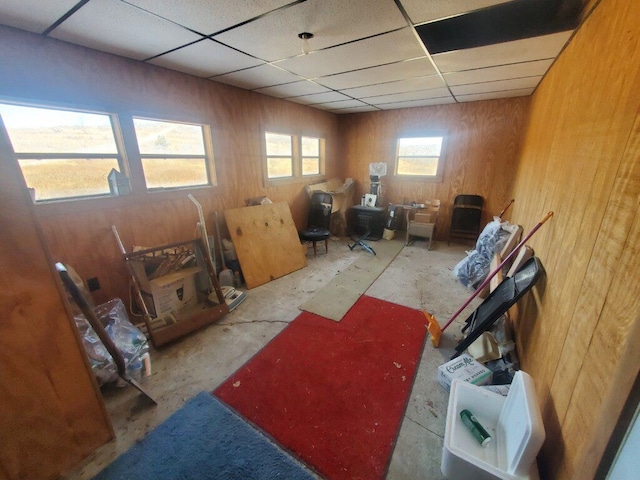 misc room featuring a paneled ceiling and wood walls