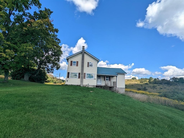 back of property featuring a lawn and a porch