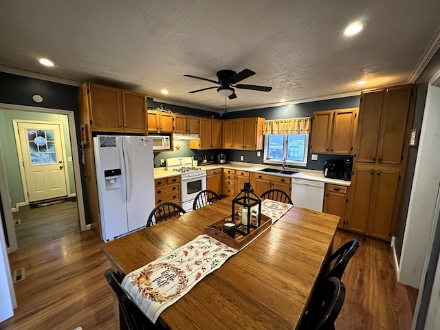 kitchen featuring white appliances, dark hardwood / wood-style floors, crown molding, and sink