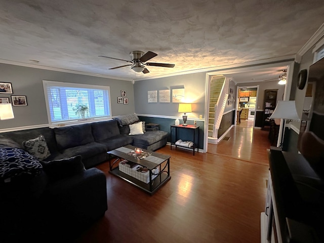 living room with crown molding, ceiling fan, and hardwood / wood-style flooring