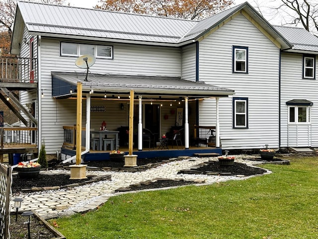 rear view of house featuring a yard