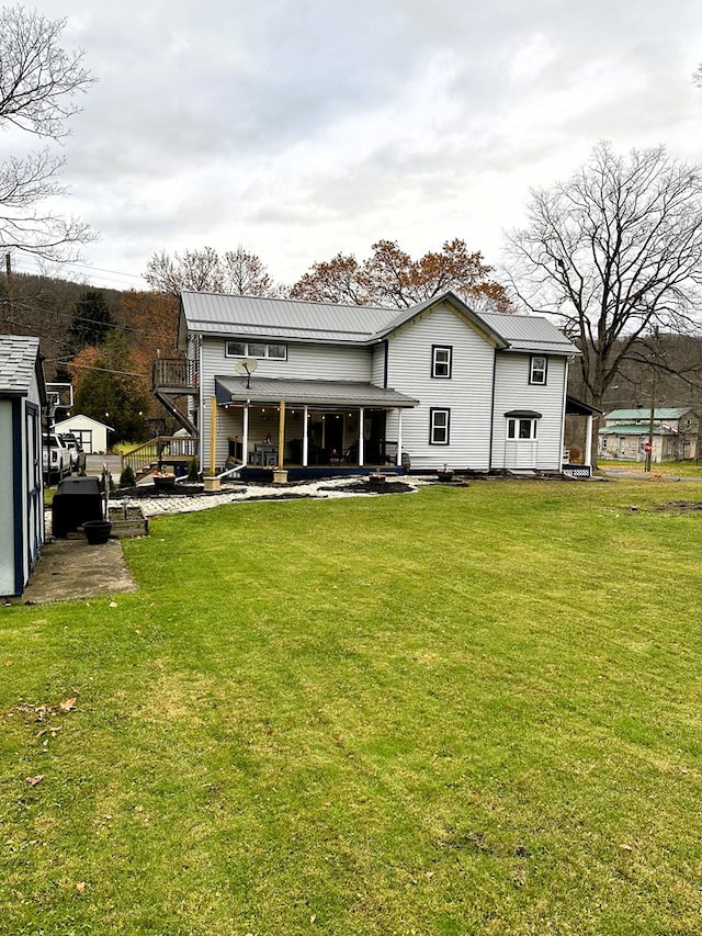 back of house with a lawn and a patio area