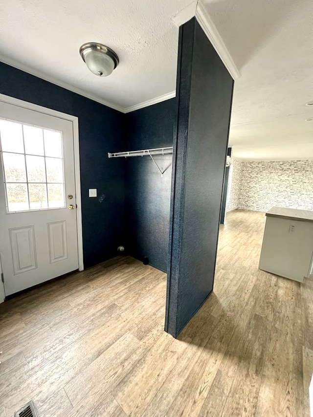 interior space with crown molding and light hardwood / wood-style flooring