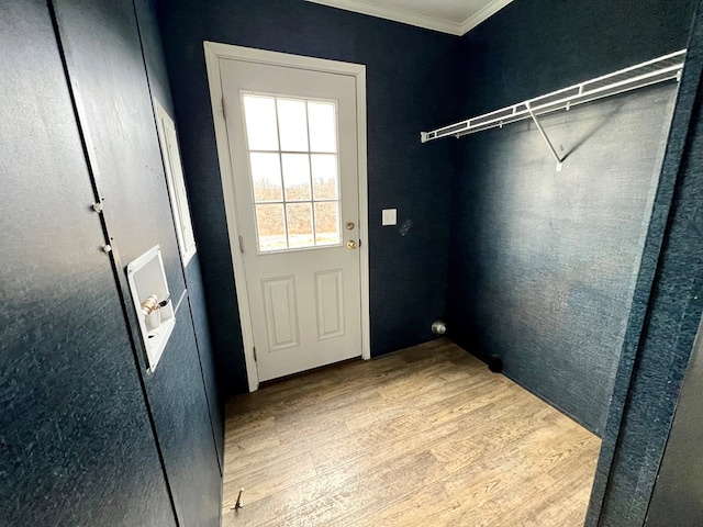 doorway with crown molding and light hardwood / wood-style floors