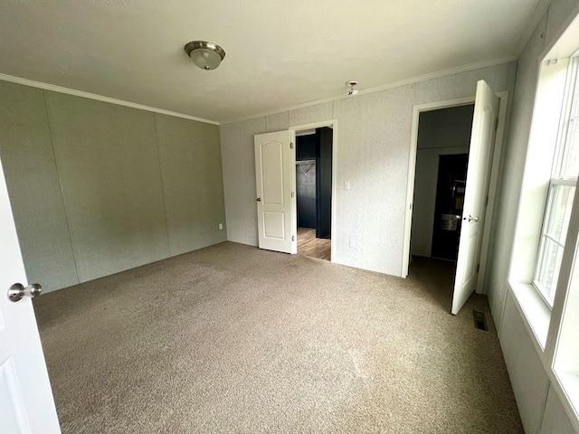 unfurnished bedroom with light colored carpet and crown molding