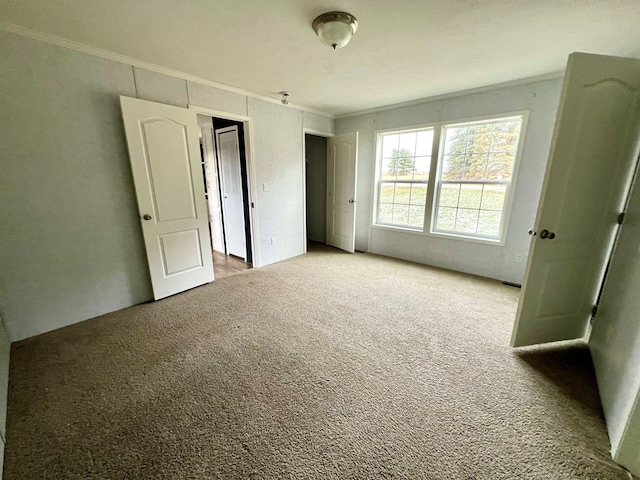 unfurnished bedroom featuring light colored carpet and crown molding