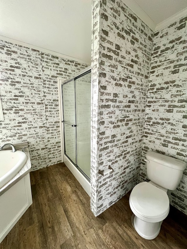 bathroom with a shower with door, vanity, ornamental molding, and hardwood / wood-style flooring