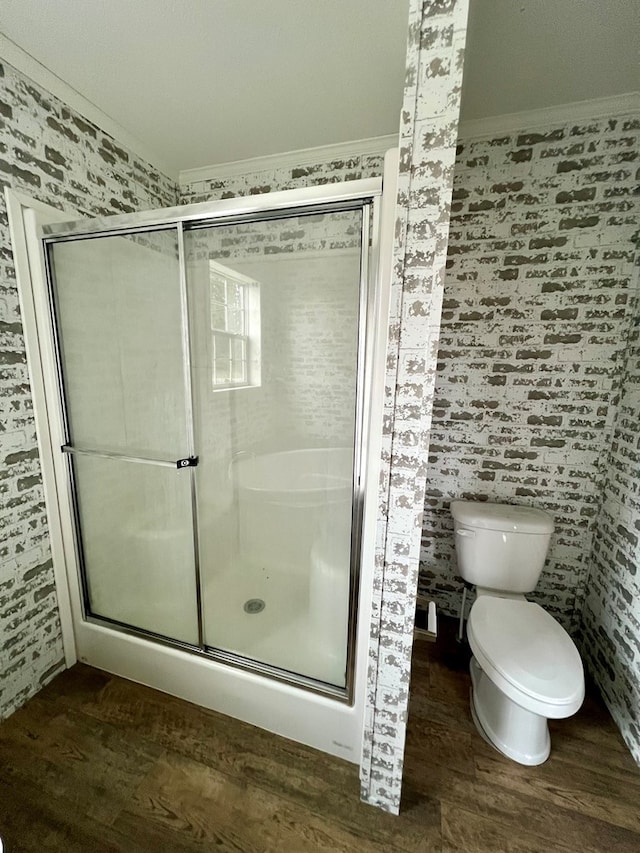 bathroom with hardwood / wood-style floors, toilet, an enclosed shower, and crown molding