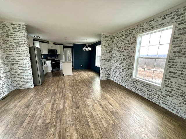 unfurnished living room with dark wood-type flooring and a notable chandelier