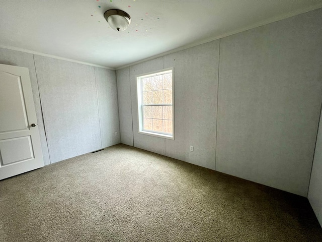 unfurnished room with carpet and crown molding