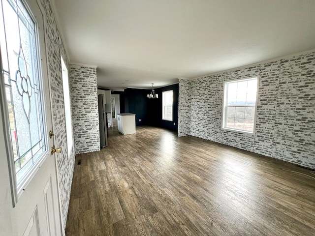 unfurnished living room with dark wood-type flooring and a chandelier