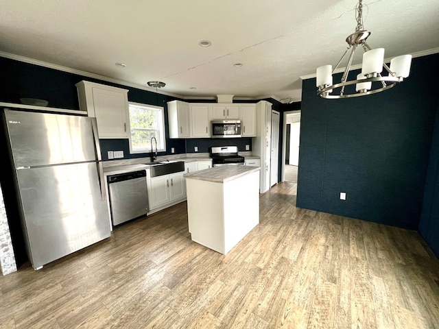 kitchen featuring stainless steel appliances, white cabinetry, and light hardwood / wood-style flooring