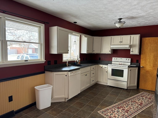 kitchen with white cabinets, white appliances, sink, and a textured ceiling