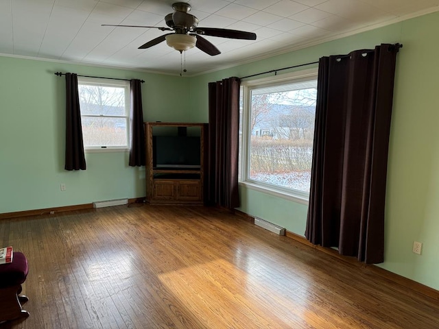 interior space featuring light hardwood / wood-style floors, baseboard heating, ceiling fan, and crown molding