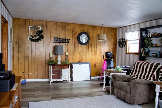 living room with hardwood / wood-style flooring, a textured ceiling, and wood walls