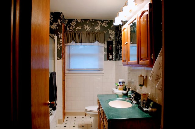 bathroom with vanity, tile walls, and toilet