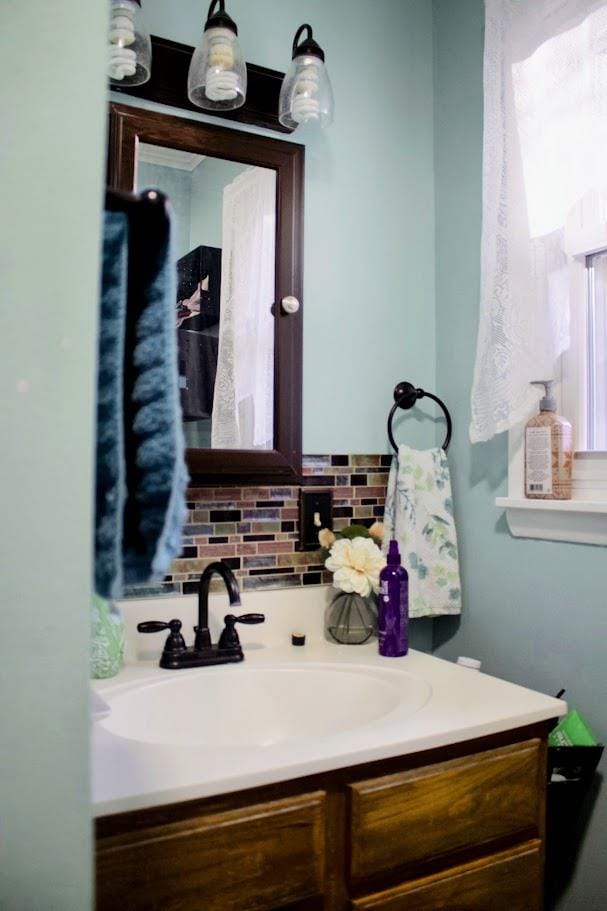 bathroom with vanity and decorative backsplash