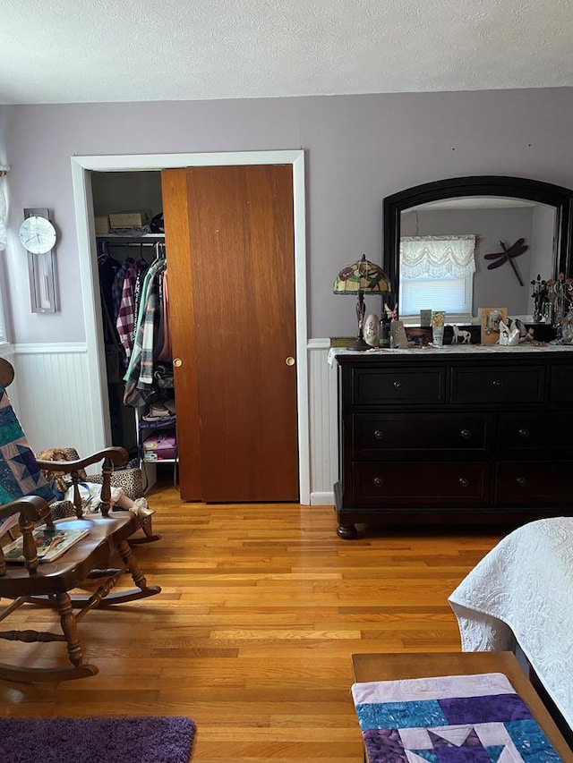 bedroom featuring a closet, a textured ceiling, and light wood-type flooring