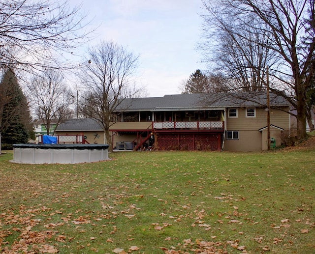 back of property with a lawn and a covered pool