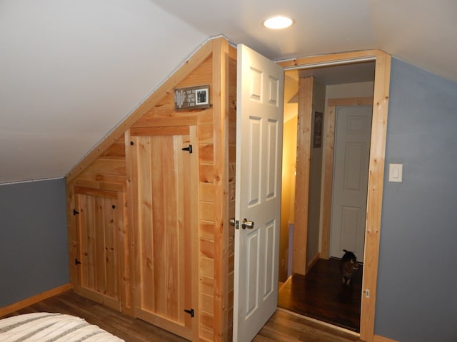 bonus room with dark wood-type flooring and lofted ceiling