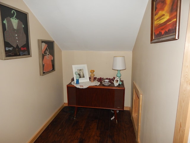 hallway featuring dark hardwood / wood-style flooring and vaulted ceiling