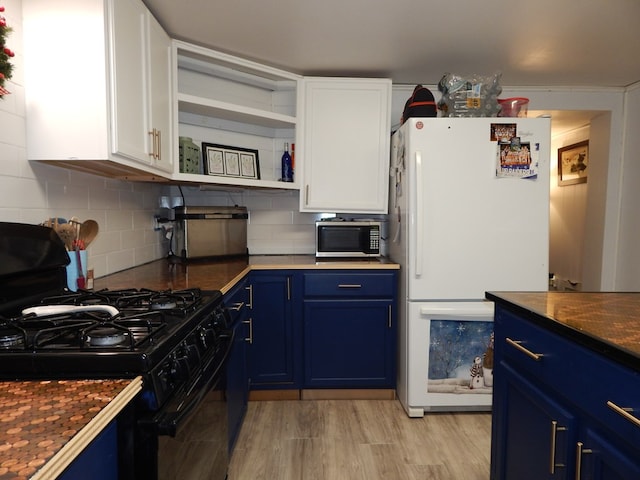 kitchen with backsplash, white cabinets, black range with gas stovetop, blue cabinetry, and white fridge