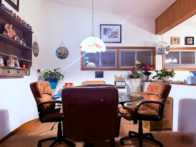 dining space featuring light colored carpet and vaulted ceiling